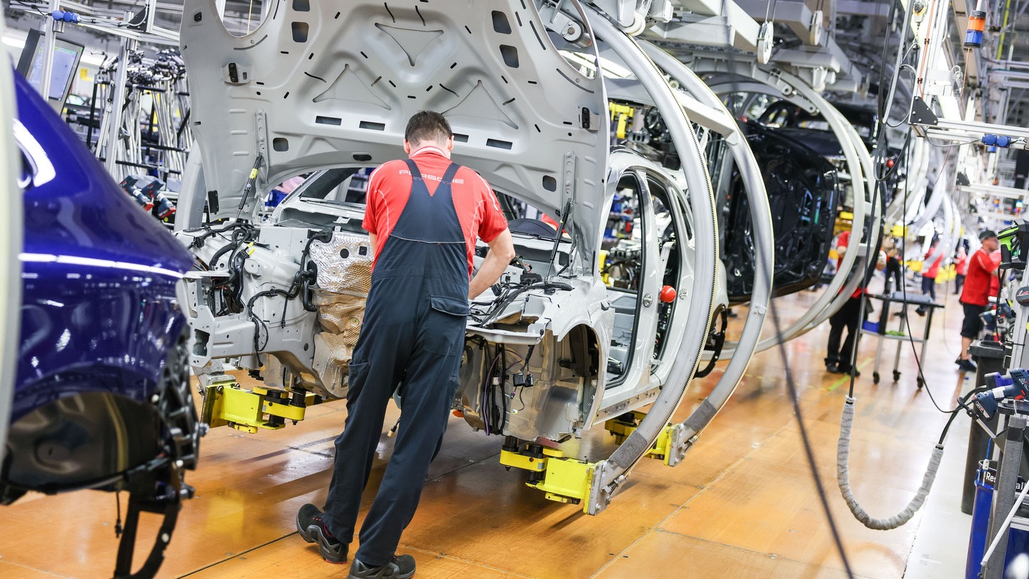 Ein Monteur arbeitet an einem Fahrzeug. Auch die Autoindustrie ist von Gewinneinbruch und Stellenabbau betroffen. Baden-Württemberg hat nun die EU aufgefordert, die Branche zu stärken (Symbolbild).