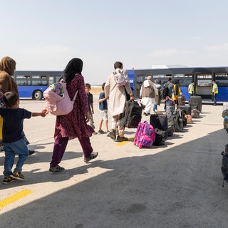 (Symbolbild) Afghanische Flüchtlinge gehen kurz nach einem Evakuierungsflug aus Kabul zu einem Bus. Im Rahmen eines Bundesaufnahmeprogramms konnten "besonders gefährdete" Menschen aus Afghanistan nach Deutschland fliehen. Die Zahlen der Geflüchteten nehmen aber seit Jahren ab auch in Baden-Württemberg.