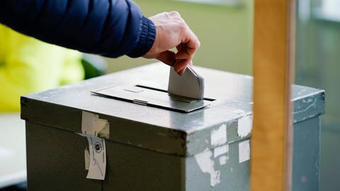 Eine Wählerin wirft ihren Stimmzettel in die Wahlurne eines Wahllokals. 