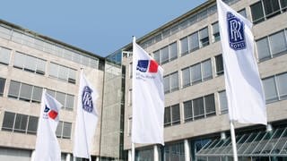 Rolls-Royce Power Systems Friedrichshafen bekommt den Umwelttechnikpreis Baden-Württemberg. Firmengebäude mit Fahnen davor.