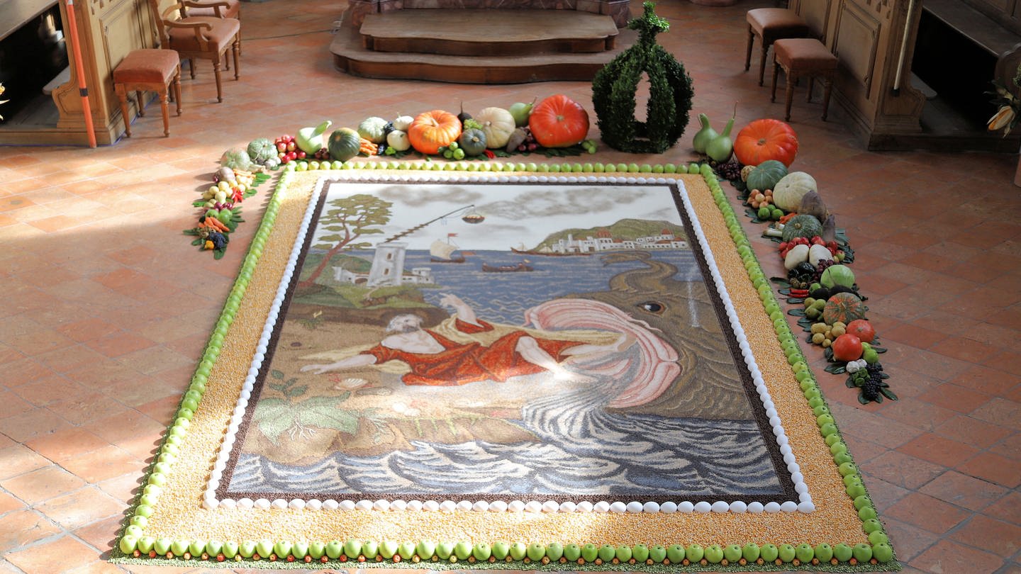 Ein bunter Teppich aus Samen und Körnern liegt auf dem Boden des Altarraumes in der Kirche von Otterswang