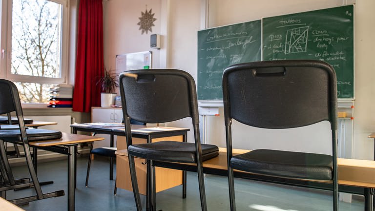 Auf Schreibtischen aufgestellte Stühle in einem Klassenzimmer einer Schule (Symbolfoto)
