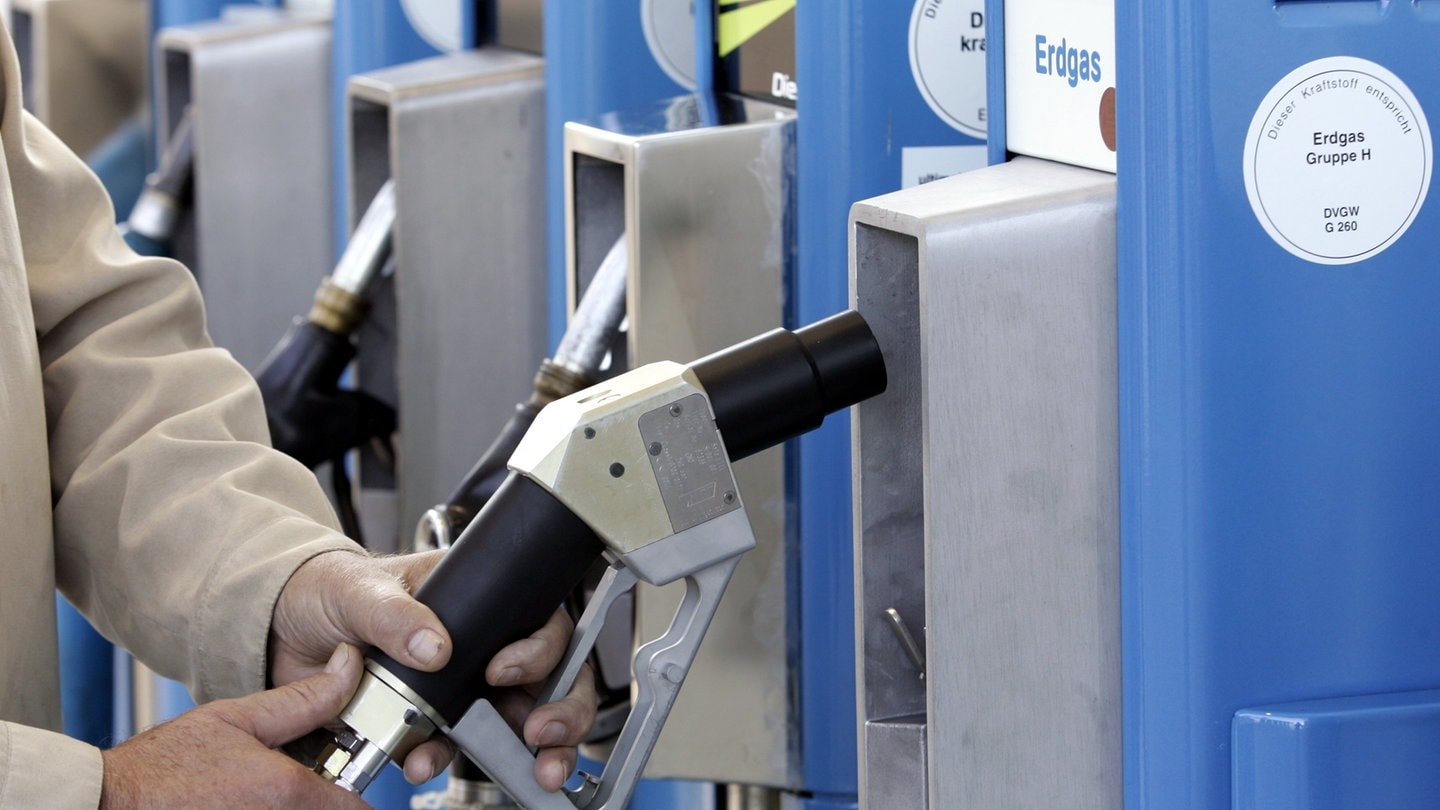 Hand am Erdgas-Zapfhahn an einer Tankstelle