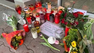 Kerzen liegen vor Geschäft in Markdorf für getötete Frau