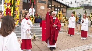 Palmenboschen werden am Palmsonntag vor der Kirche in Baustetten geweiht