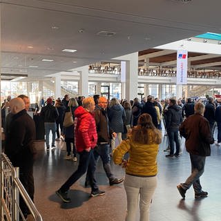 Auf dem Weg zur Betriebsversammlung: Beschäftigte von Rolls-Royce Power Systems kommen in Friedrichshafen auf dem Messegelände zusammen.