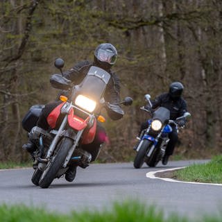 Zwei Motorradfahrer fahren um eine Kurve.