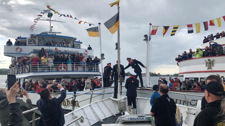 Die Schiffsbesatzungen von drei Schiffen geben sich die Hand