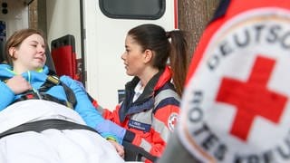 Frau wird in Rettungswagen geladen