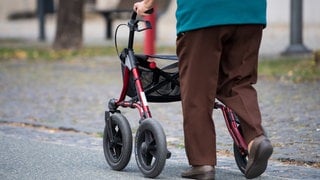 Eine ältere Frau am Rollator.