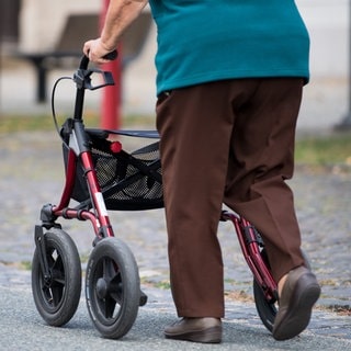 Eine ältere Frau am Rollator.