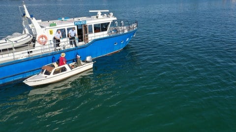 Falko Brögeler (l) und Jens Ludewig (r) von der Wasserschutzpolizei Friedrichshafen kontrollieren auf dem Bodensee vor Langenargen zwei Fischer. (Aufnahme mit einer Drohne. Zu dpa: «Streife fahren auf dem Bodensee - die Arbeit der Wasserschutzpolizei»)