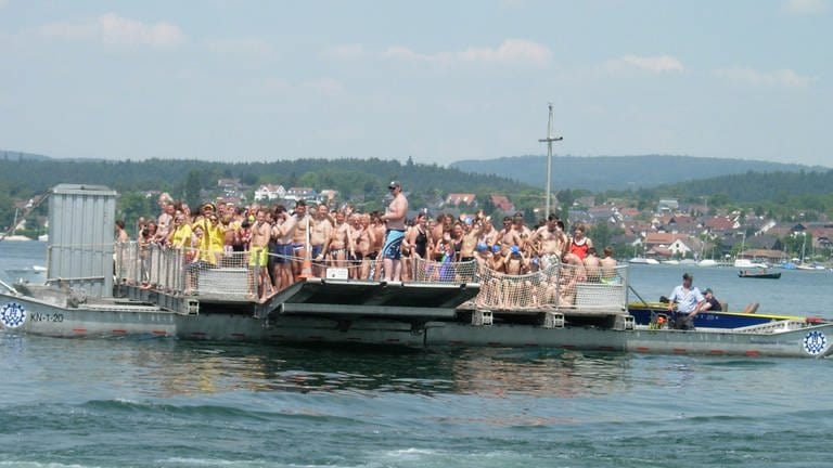 Menschen in Badekleidung auf einer Fähre auf dem Gnadensee 