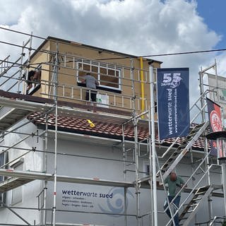 Die neue Wetterbeobachtungsstation der Wetterwarte Süd ist von Bauarbeitern auf das Dach gehievt worden.