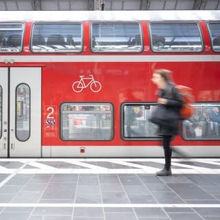 Ein Zug der Deutschen Bahn hält an einem Bahnhof. 