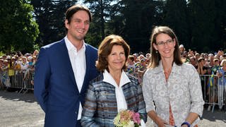 Königin Silvia von Schweden bei ihrem letzten Besuch auf der Insel Mainau 2019. Links der Schlossherr, Björn Graf Bernadotte, rechts seine Schwester, Bettina Gräfin Bernadotte.