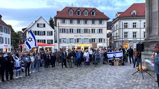 Menschen stehen mit der Israel-Fahne vor dem Konstanzer Münster