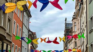 Schmitterlinge aus alten Regenschirmen hängen über den Straßen der Altstadt in Konstanz.