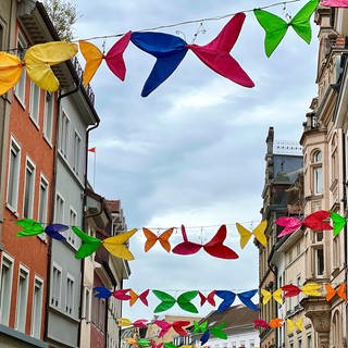 Schmitterlinge aus alten Regenschirmen hängen über den Straßen der Altstadt in Konstanz.