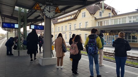 Reisende warten am Bahnhof Friedrichshafen Stadt auf Zug