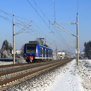 Ein Zug in Oberzell bei Ravensburg in verschneiter Winterlandschaft.
