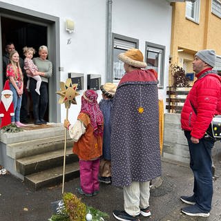 In Isny im Allgäu sind Sternsinger unterwegs und sammeln Spenden