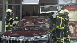 Ein Auto steckt im Schaufenster eines Friseursalons
