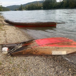 Zwei Teile eines Holzbootes am Seeufer