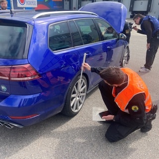 Polizeibeamte kontrollieren getunte Fahrzeuge im Umfeld der Messe "Tuning World Bodensee" in Friedrichshafen.