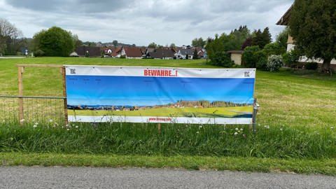 Gegner der Windkraftanlagen im Altdorfer Wald haben Plakate aufgestell. Auf ihnen steht "Bewahre... ", mit einem Foto des Altdorfer Walds im Hintergrund