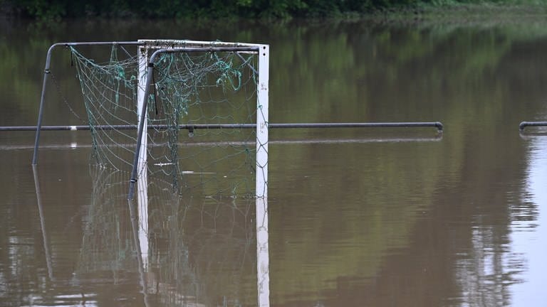 Auf einem überfluteten Sportplatz spiegelt sich ein Fußballtor im Wasser. Die Schussen hatte Teile von Meckenbeuren überschwemmt.