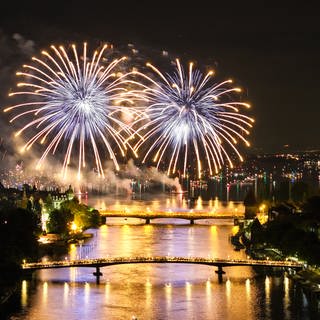 Hunderte Menschen verfolgen in Konstanz, von zwei über den Rhein führenden Brücken aus, das Feuerwerk des Konstanzer Seenachtfestes.