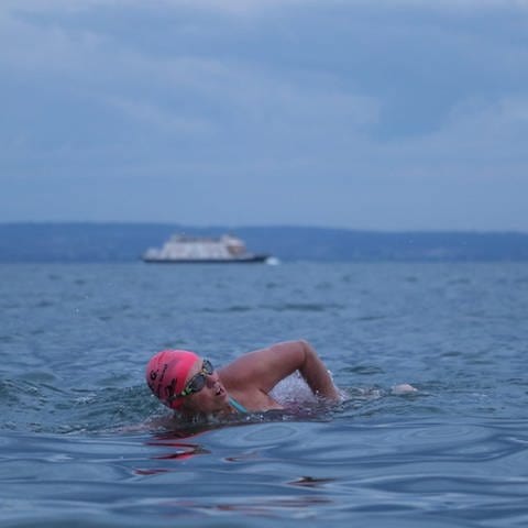 Iris Ashman, mit Schwimmbrille und Bademütze, schwimmt im Bodensee zwischen Bodman und Bregenz.