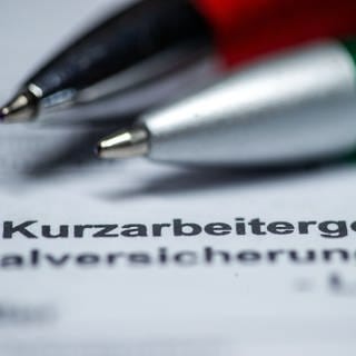 Zwei Kugelschreiber liegen auf einem Antragsformular für Kurzarbeitergeld