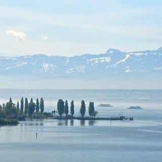 Zwei Fähren fahren bei Meersburg vor dem Panorama der Schweizer Alpen über den Bodensee. 