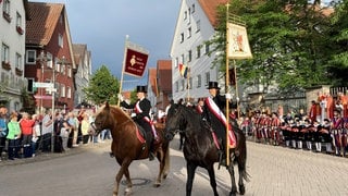 Reiter reiten mit Pferden durch eine Straße in Bad Wurzach