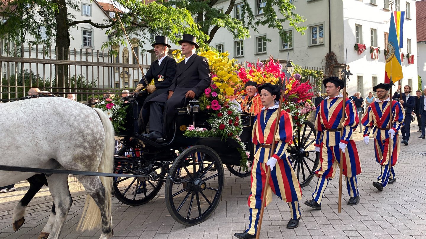 Der sogenannte Heilig-Blut-Wagen wird begleitet von jungen Männern in bunten Schweizer Gardeuniformen