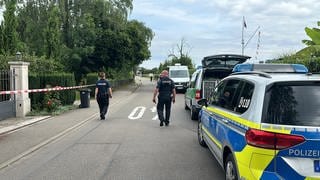 Polizeiauto und zwei Polizisten auf einer Straße bei Kressbronn
