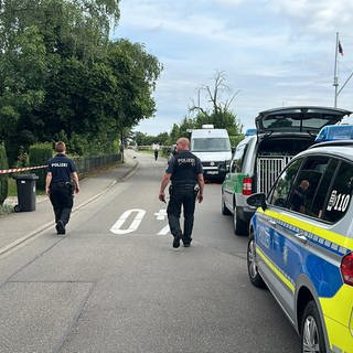 Polizeiauto und zwei Polizisten auf einer Straße bei Kressbronn