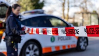 Polizistin hält Polizeiabsperrband