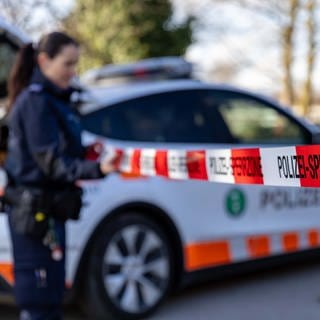 Polizistin hält Polizeiabsperrband