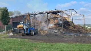 Löschfahrzeuge vor abgebrannter Halle in Biberach