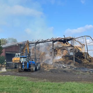 Löschfahrzeuge vor abgebrannter Halle in Biberach