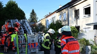 Feuerwehrleute sind am Ort eines Brandes im Einsatz. Beim Brand in einem Reihenmittelhaus in Ravensburg ist eine 82-jährige Frau tödlich verletzt worden.