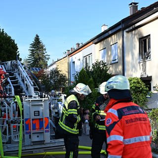 Feuerwehrleute sind am Ort eines Brandes im Einsatz. Beim Brand in einem Reihenmittelhaus in Ravensburg ist eine 82-jährige Frau tödlich verletzt worden.