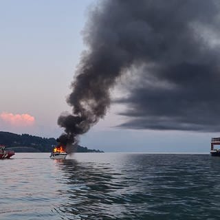 Einsatzkräfte löschen ein brennendes Motorboot auf dem Bodensee