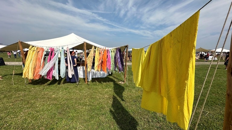 Gefärbte Tuche trocknen in der Sonne beim Keltenfest auf der Heuneburg.