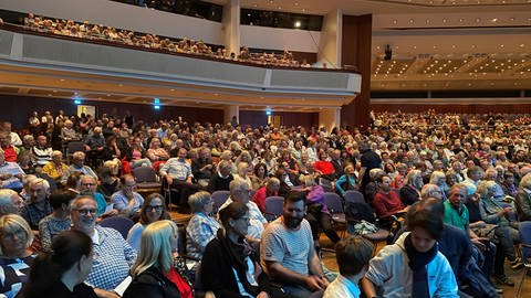 Viele Menschen sitzen im Graf-Zeppelin-Haus bei der Kandidatenvorstellung zur OB-Wahl in Friedrichshafen.