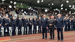 Polizeianwärter werfen in Biberach Hüte in die Höhe, Innenminister Strobl schaut zu