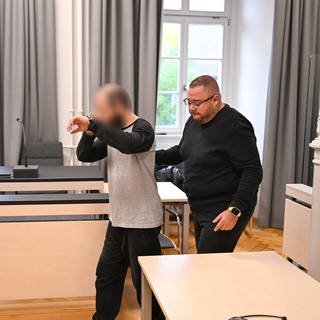 Angeklagter wird in Gerichtssaal hineingeführt